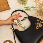 Sachet de bain de bouche menthe 12 ml tenu à la main et glissé dans un sac, format nomade sans alcool ni sucre.